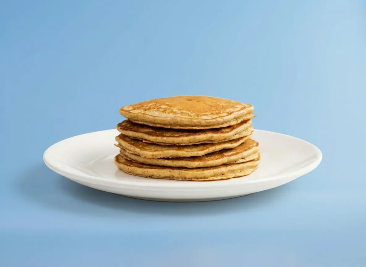 Bild von Protein Pancakes auf einem Teller vor blauem Hintergrund.
